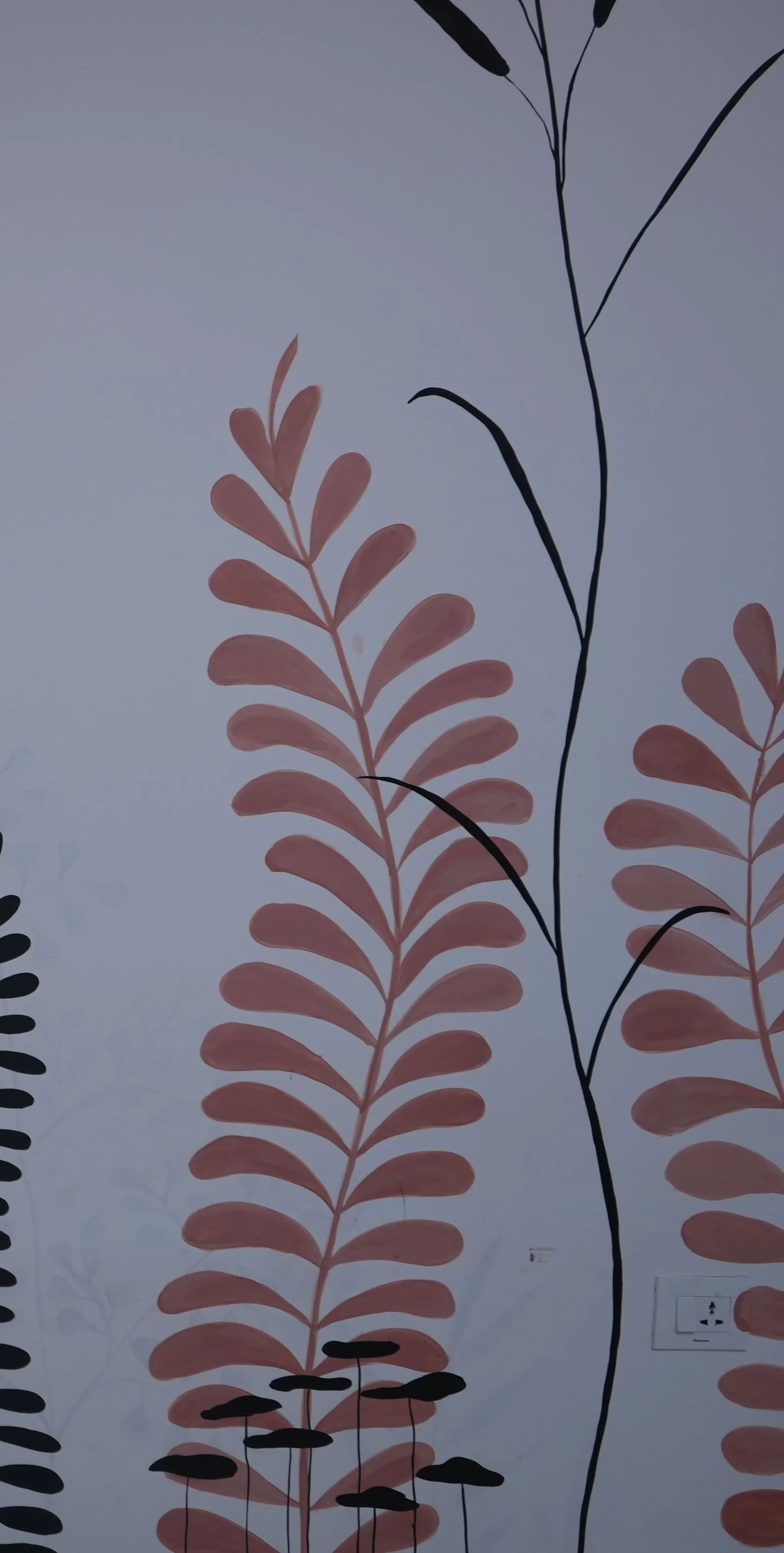 Detail: coral-red fern fronds, the one colour allowed onto the wall