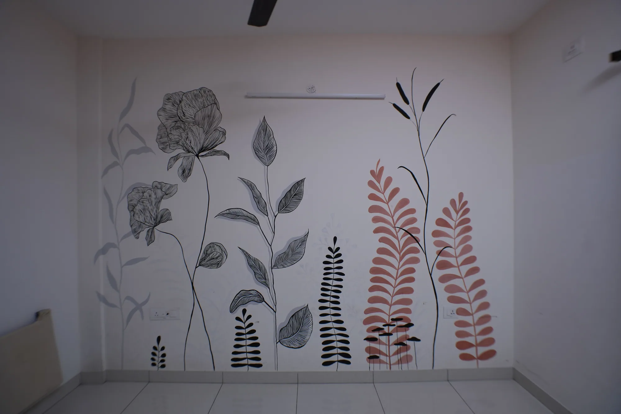 A full wall drawn with large botanical studies in black ink, with coral-red fern fronds among them