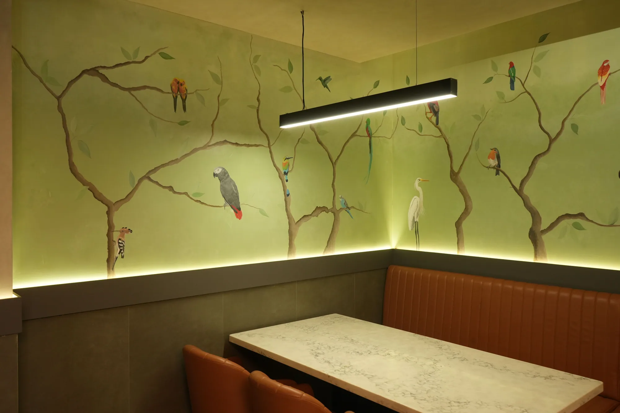 A second dining alcove in the same hotel, its walls painted on an olive-green ground